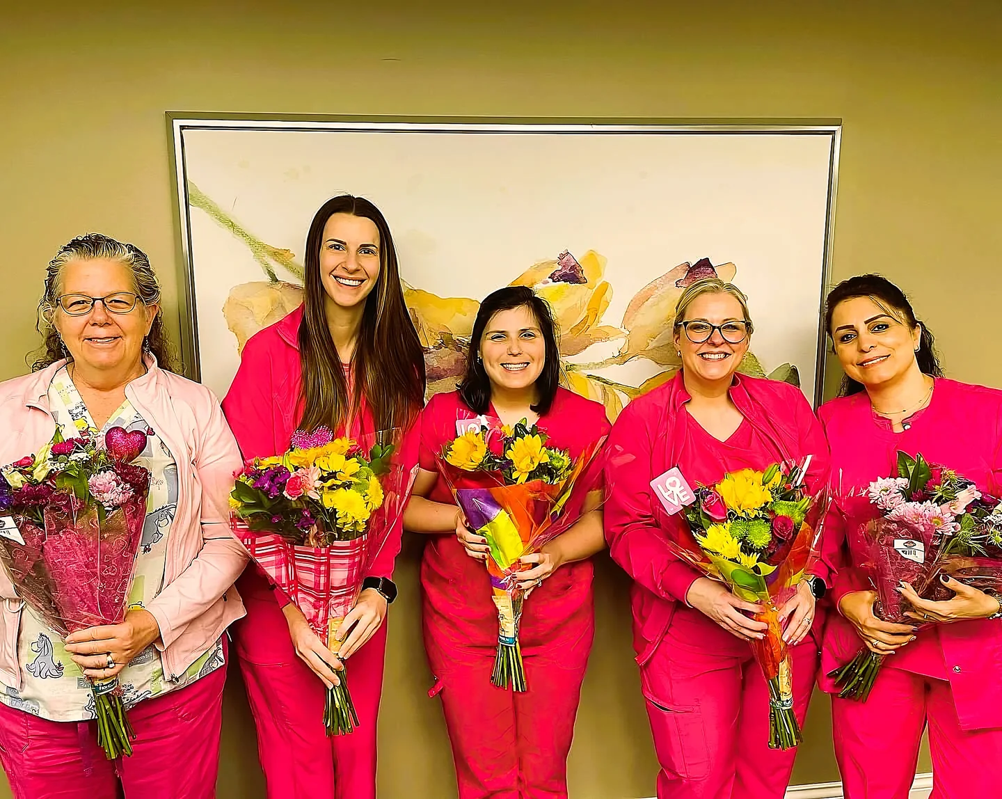 The Schrock Dental team holding bouquets of flowers