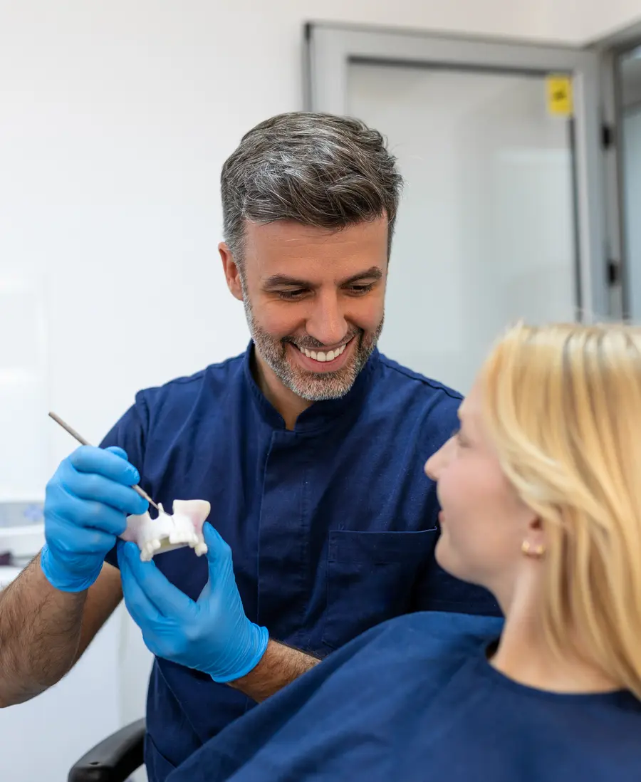 A dentist showing a patient a tooth model